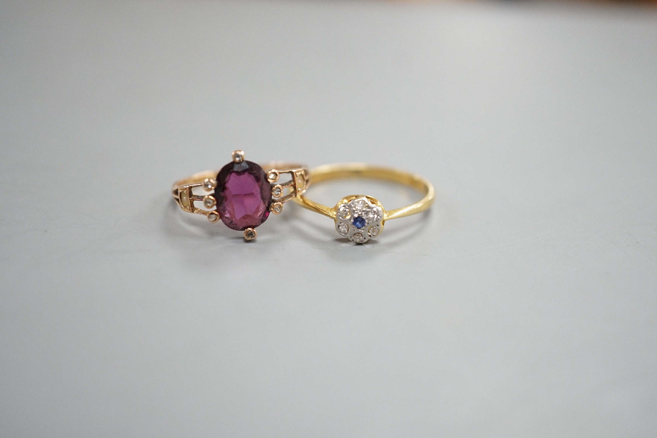 A small 1920's 18ct, sapphire and diamond cluster set flower head ring, size P/Q, gross weight 2.3 grams and a yellow metal, garnet?, split pearl and diamond chip set oval cluster ring, gross weight 2 grams.